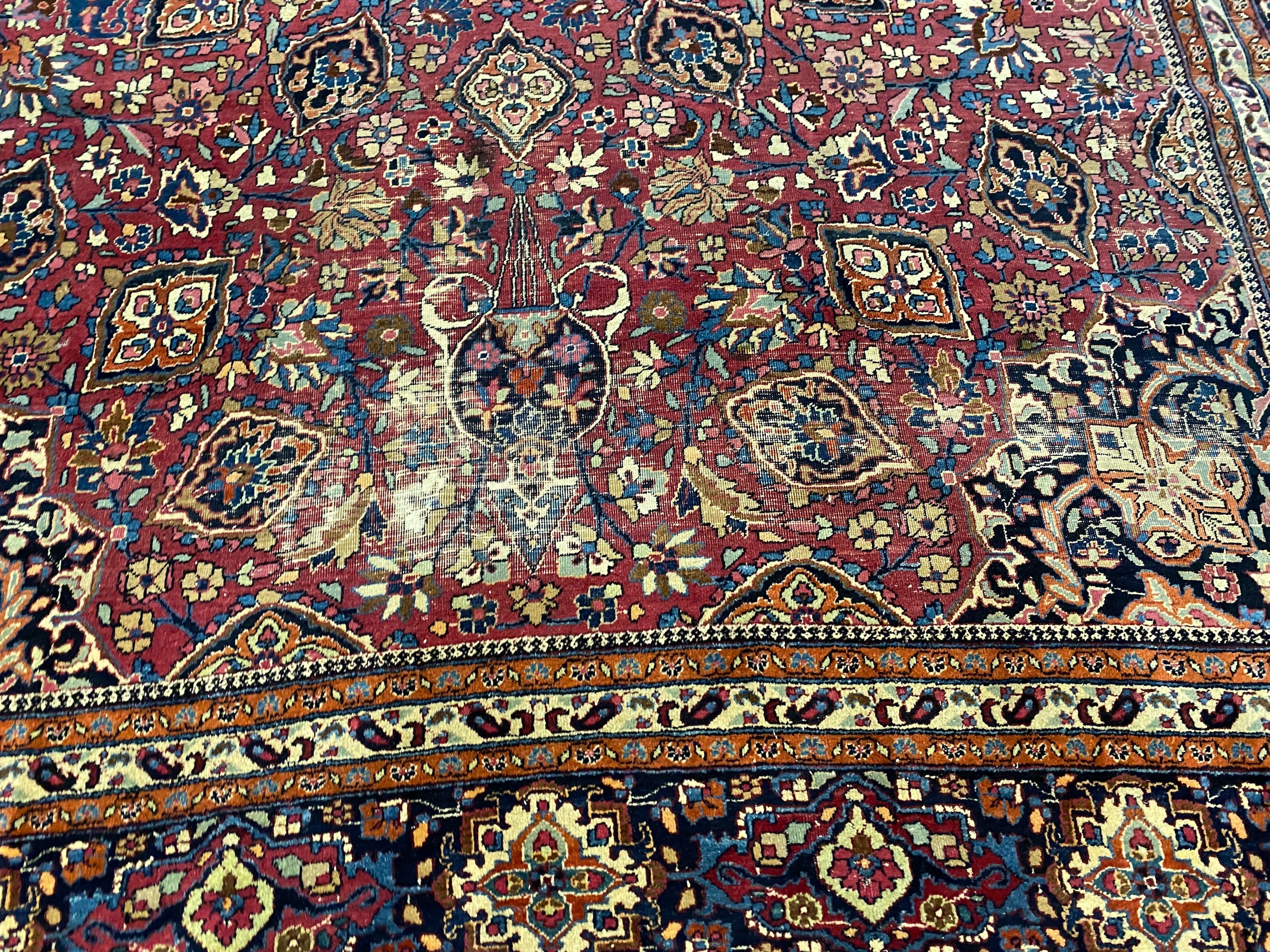 An early 20th century Heriz burgundy ground carpet, 412 x 305cm